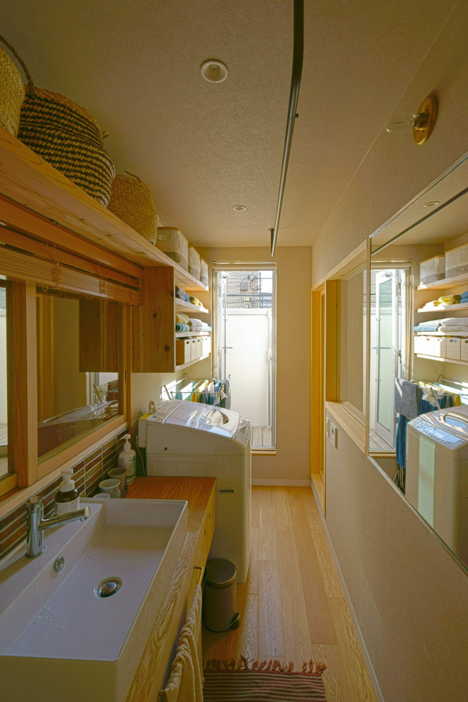Photo of a small scandinavian cloakroom in Tokyo with flat-panel cabinets, beige cabinets, brown tiles, matchstick tiles, grey walls, plywood flooring, wooden worktops, beige floors, beige worktops, feature lighting, a built in vanity unit, a wallpapered ceiling and wallpapered walls.