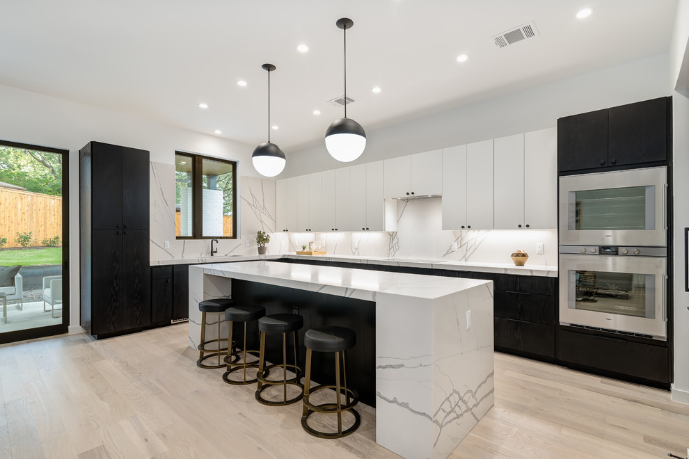 Design ideas for a mid-sized contemporary l-shaped kitchen in Austin with flat-panel cabinets, marble benchtops, light hardwood floors, with island, white benchtop, white splashback, marble splashback, stainless steel appliances, beige floor and an undermount sink.