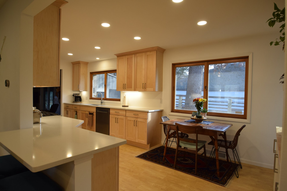 Inspiration for a galley vinyl floor kitchen remodel with an undermount sink, shaker cabinets, light wood cabinets, quartz countertops, stainless steel appliances and white countertops