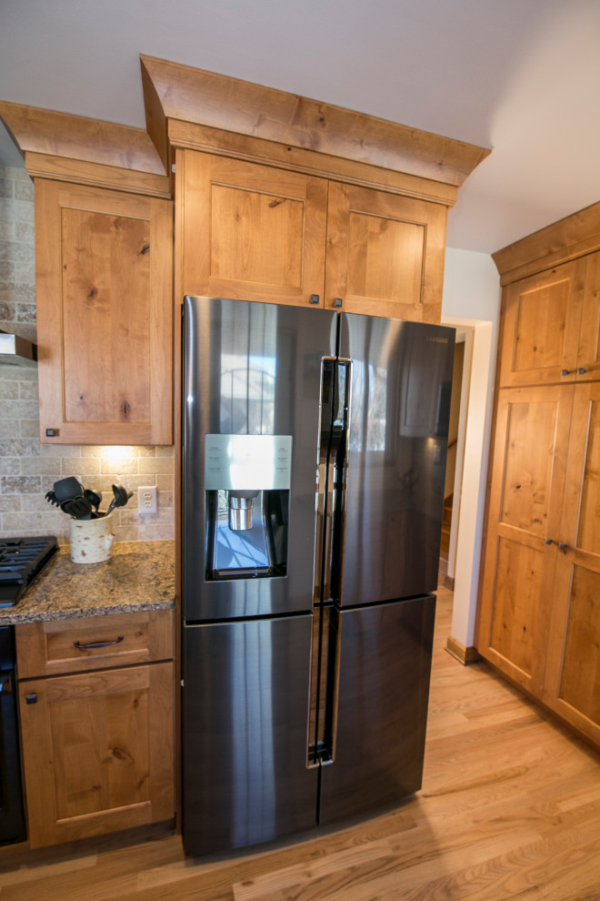 Mid-sized mountain style galley medium tone wood floor and brown floor eat-in kitchen photo in Denver with an undermount sink, shaker cabinets, medium tone wood cabinets, quartz countertops, gray backsplash, stone tile backsplash, black appliances, no island and brown countertops