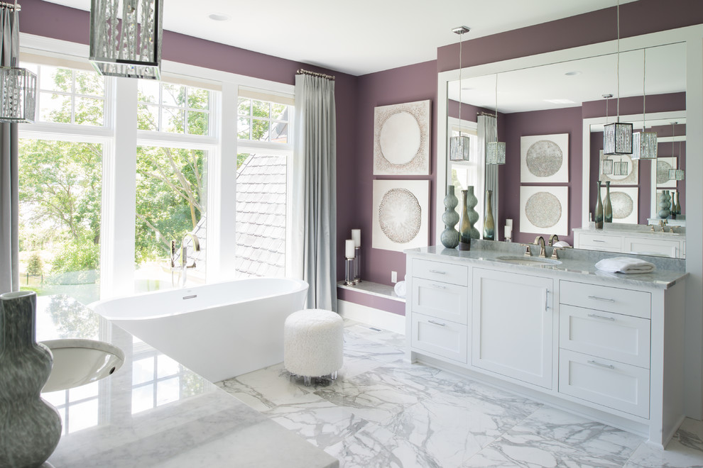 Design ideas for a large transitional master bathroom in Minneapolis with shaker cabinets, white cabinets, a freestanding tub, purple walls, marble floors, an undermount sink, marble benchtops and grey floor.