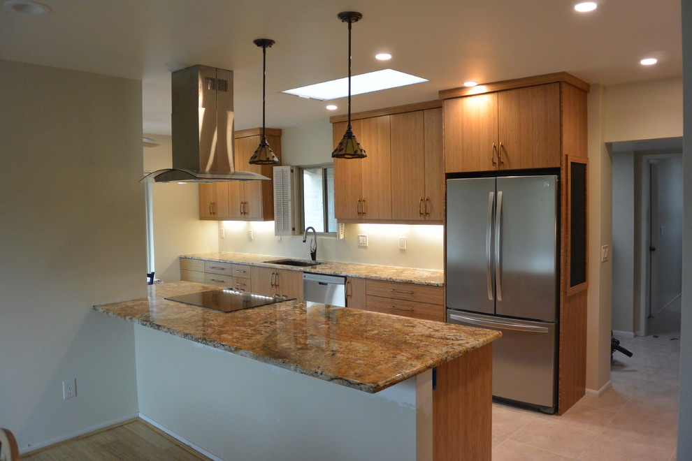 Example of a transitional u-shaped porcelain tile and beige floor eat-in kitchen design with an undermount sink, flat-panel cabinets, light wood cabinets, granite countertops, stainless steel appliances, a peninsula and brown countertops