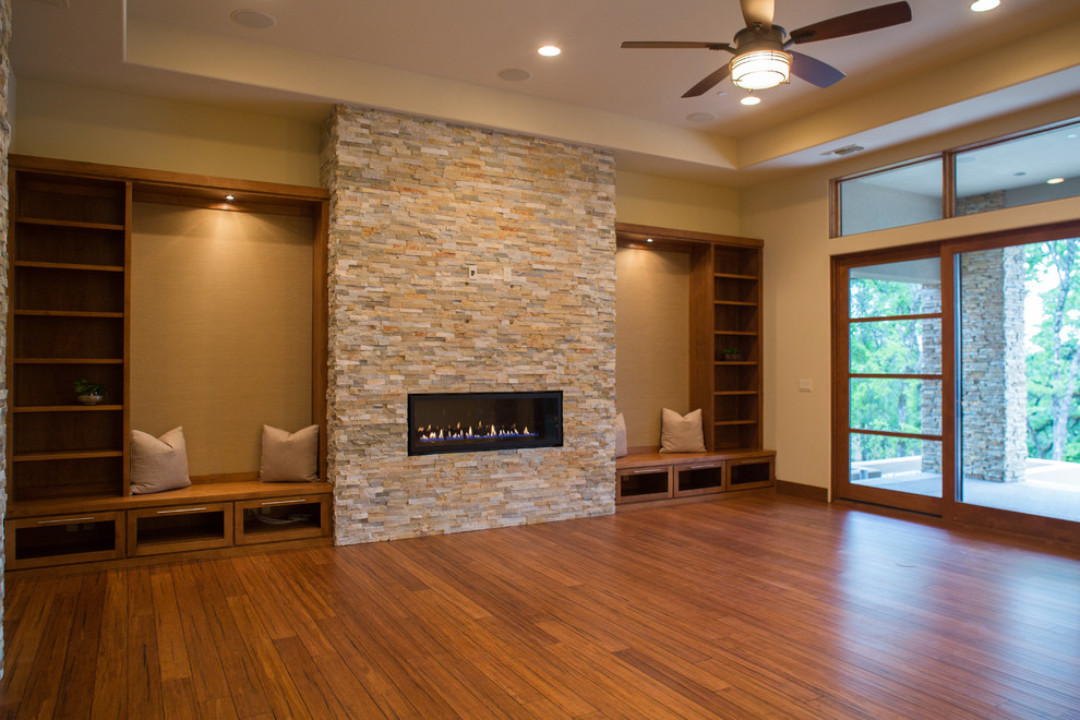 Photo of a large contemporary formal open concept living room in Sacramento with beige walls, bamboo floors, a ribbon fireplace, a stone fireplace surround, no tv and brown floor.