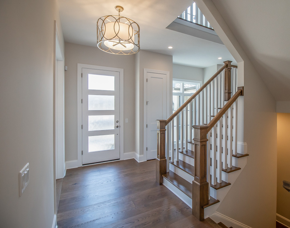 This is an example of an expansive traditional foyer in Cleveland with beige walls, medium hardwood floors, a single front door, a white front door and brown floor.