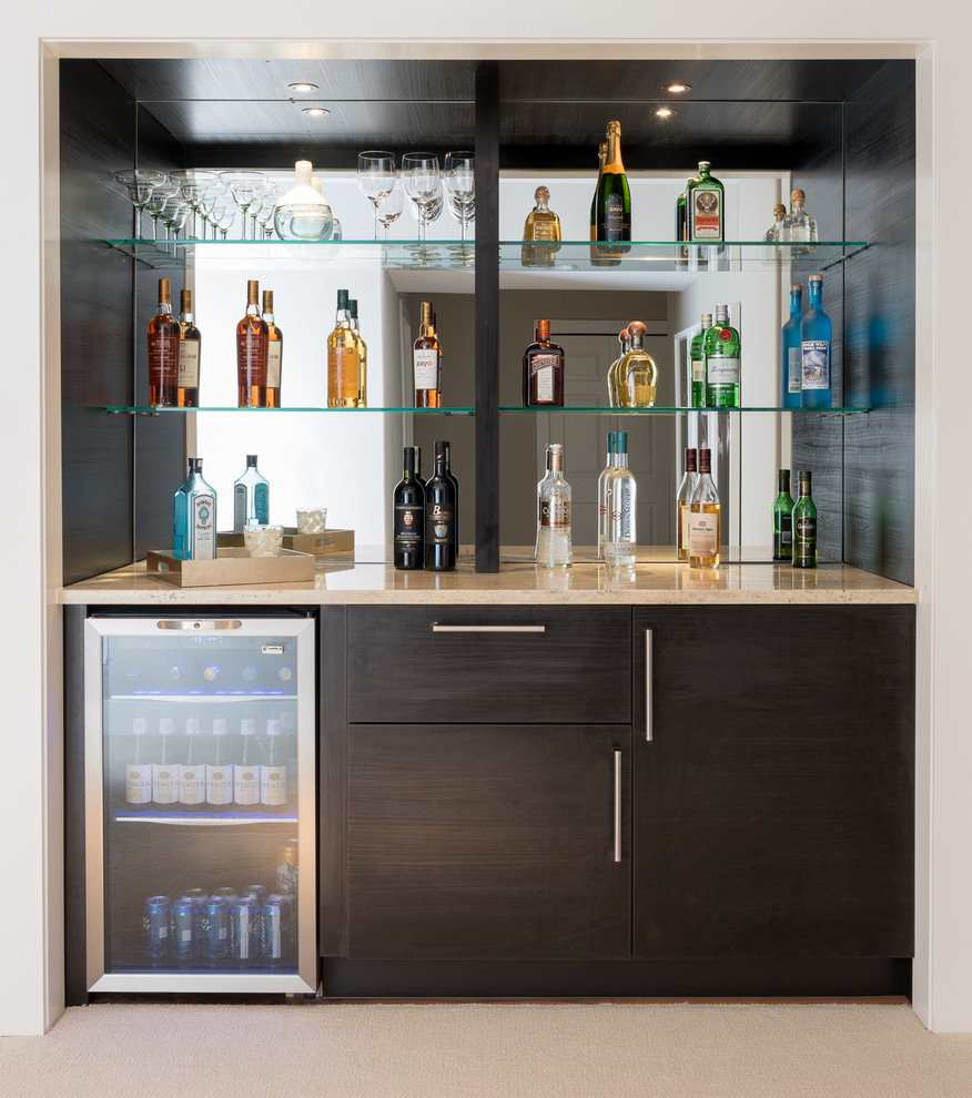 Design ideas for a modern home bar in Denver with flat-panel cabinets, dark wood cabinets, quartz benchtops, mirror splashback and carpet.