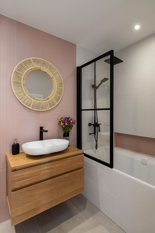 This is an example of a medium sized contemporary grey and pink ensuite bathroom in Paris with beaded cabinets, brown cabinets, a submerged bath, a wall mounted toilet, grey tiles, ceramic tiles, pink walls, ceramic flooring, a vessel sink, wooden worktops, grey floors, an open shower, brown worktops, a wall niche, a single sink and a floating vanity unit.