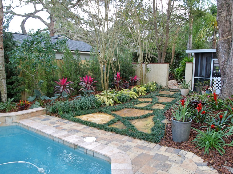 Photo of a small contemporary backyard shaded formal garden for summer in Orlando with a garden path and natural stone pavers.