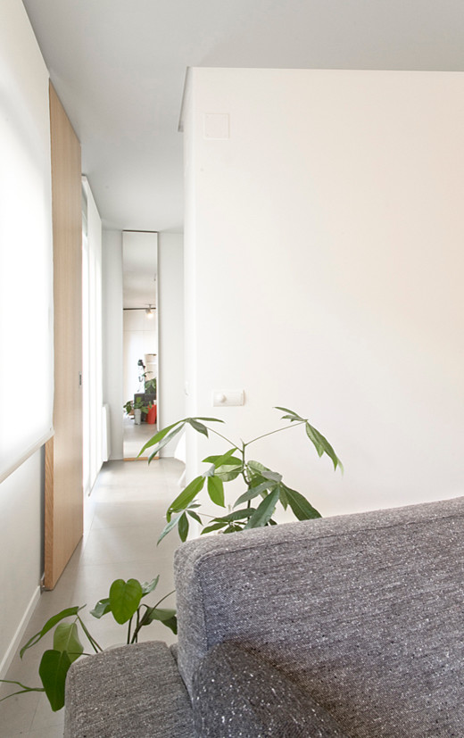 Modelo de sala de estar con biblioteca tipo loft industrial pequeña con paredes grises, suelo de cemento, todas las chimeneas y pared multimedia