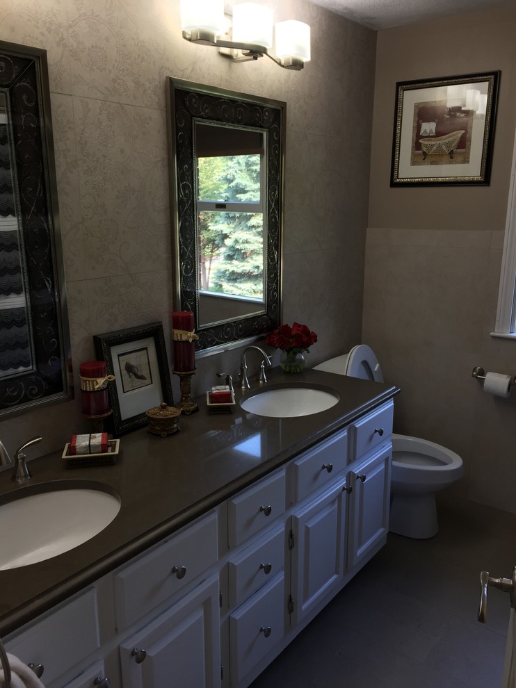 Beige tile and porcelain tile porcelain tile alcove bathtub photo in Boston with an undermount sink, white cabinets, quartz countertops, a two-piece toilet and beige walls