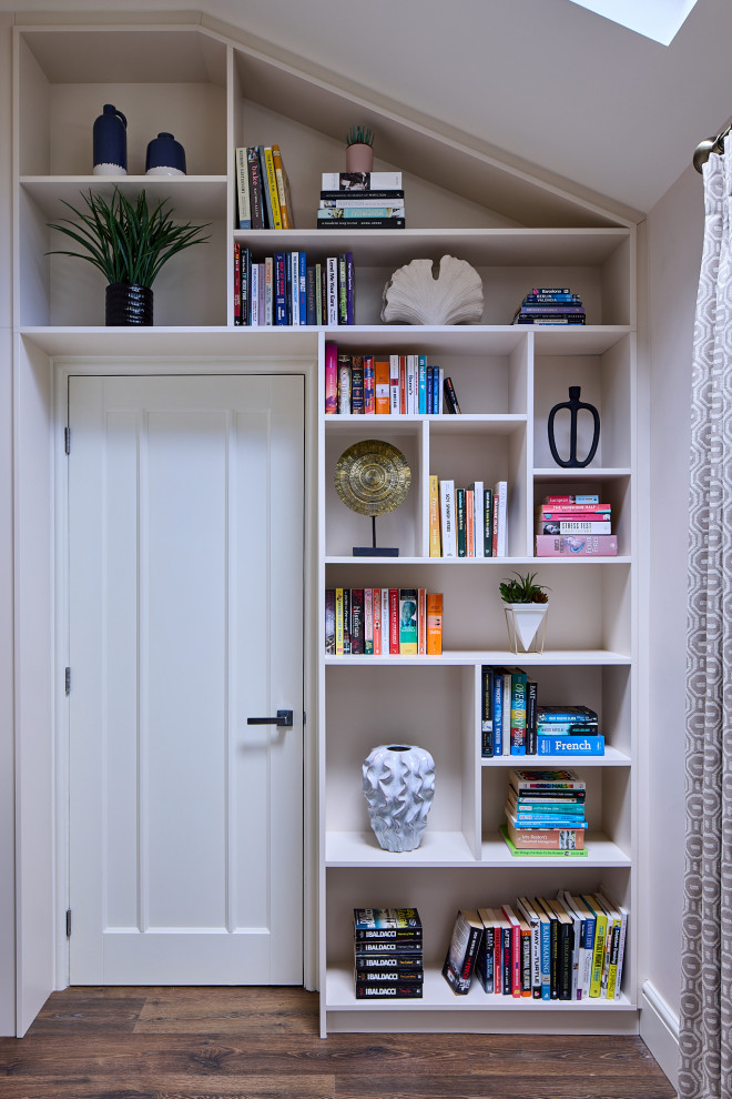 Aménagement d'un salon contemporain de taille moyenne et fermé avec une bibliothèque ou un coin lecture, un mur beige, sol en stratifié, un poêle à bois, un manteau de cheminée en bois, un téléviseur fixé au mur et un sol marron.