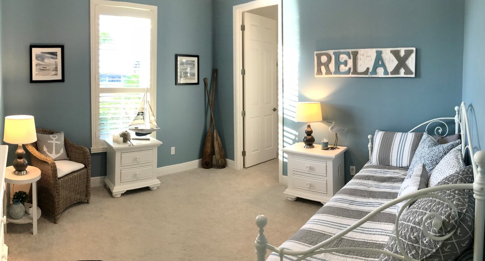This is an example of a beach style guest bedroom with blue walls, carpet, no fireplace and beige floor.