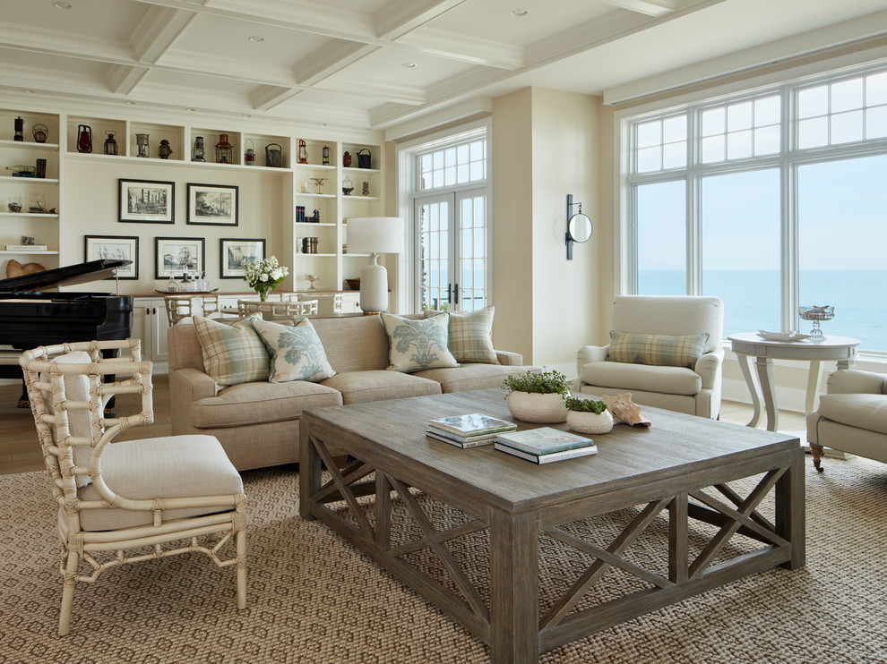 Photo of a mid-sized beach style formal open concept living room in Chicago with beige walls, medium hardwood floors, a standard fireplace, a tile fireplace surround, no tv and beige floor.