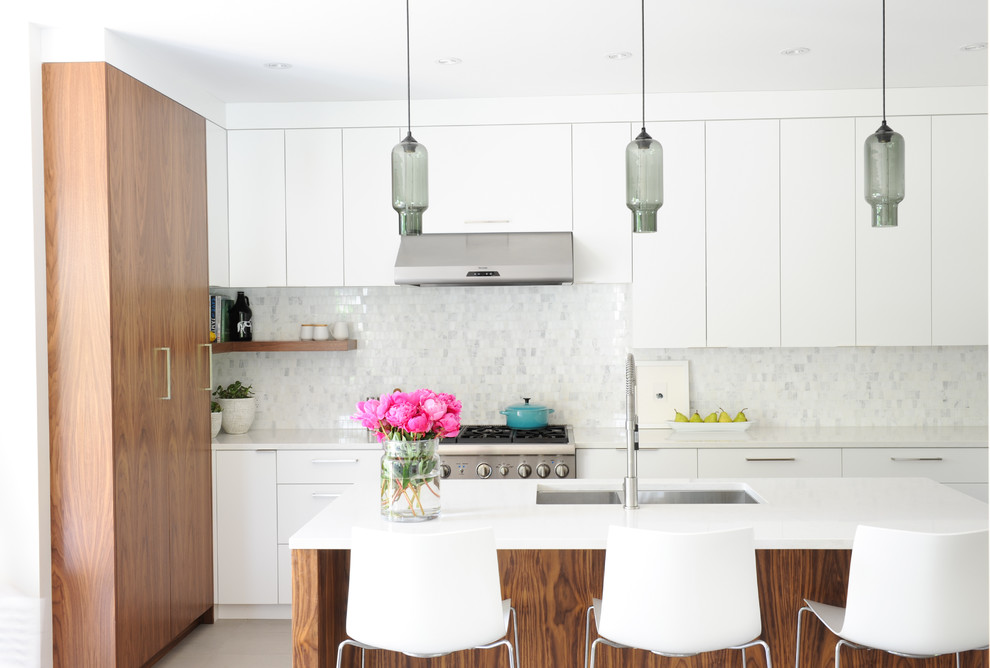 This is an example of a contemporary kitchen in Vancouver with a double-bowl sink, flat-panel cabinets, white cabinets, white splashback, mosaic tile splashback, stainless steel appliances and with island.