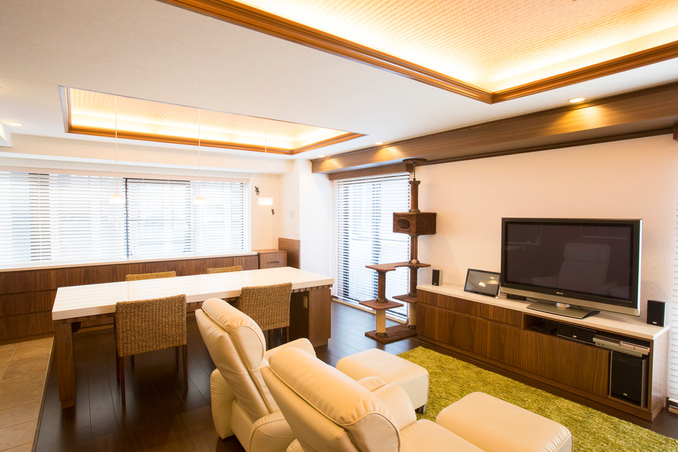 Photo of a modern living room in Tokyo with white walls, dark hardwood floors, a freestanding tv and brown floor.