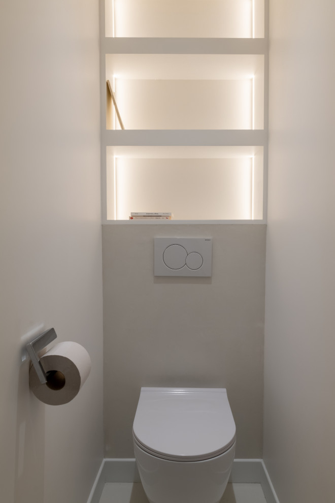 Photo of a medium sized contemporary cloakroom in Paris with open cabinets, white cabinets, a wall mounted toilet, white walls, concrete flooring, white floors and a built in vanity unit.