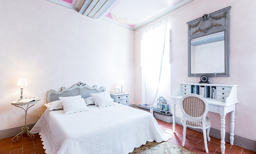 Photo of a mediterranean bedroom in Florence with beige walls and terra-cotta floors.
