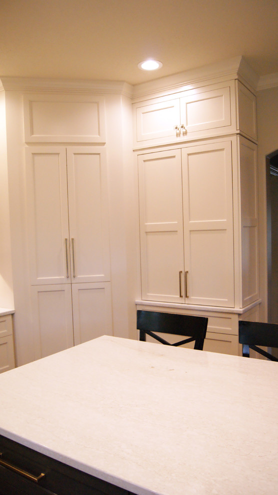 Example of a transitional kitchen design with flat-panel cabinets, white cabinets, quartz countertops, gray backsplash and white countertops