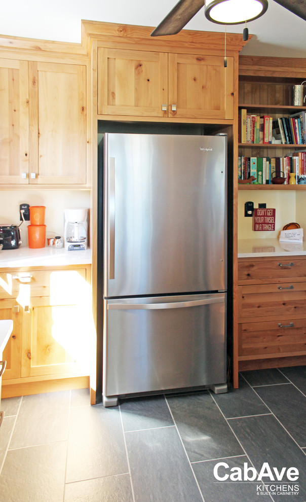 Enclosed kitchen - small rustic u-shaped slate floor and gray floor enclosed kitchen idea with a farmhouse sink, recessed-panel cabinets, medium tone wood cabinets, quartz countertops, stainless steel appliances and no island