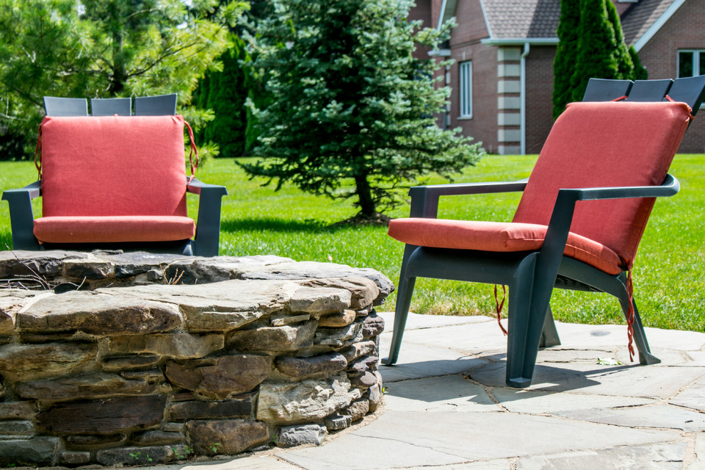 This is an example of a rustic backyard stone landscaping in Chicago with a fire pit.