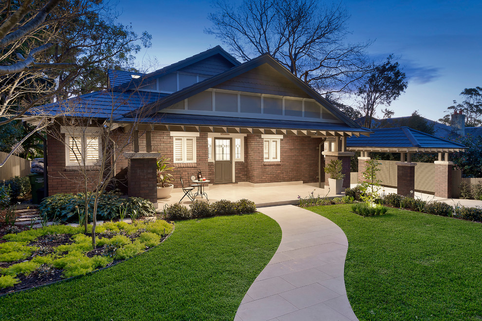 Photo of a mid-sized traditional one-storey brick brown house exterior in Sydney with a hip roof and a tile roof.