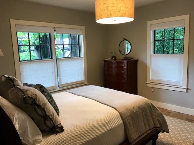 Design ideas for a mid-sized transitional guest bedroom in Atlanta with grey walls, light hardwood floors, no fireplace and beige floor.