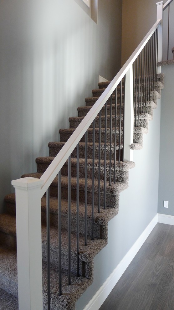 Inspiration for a small transitional carpeted l-shaped wood railing staircase remodel with carpeted risers
