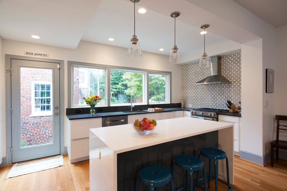 Photo of a mid-sized modern u-shaped eat-in kitchen in DC Metro with an undermount sink, flat-panel cabinets, white cabinets, quartz benchtops, grey splashback, cement tile splashback, stainless steel appliances, medium hardwood floors and with island.