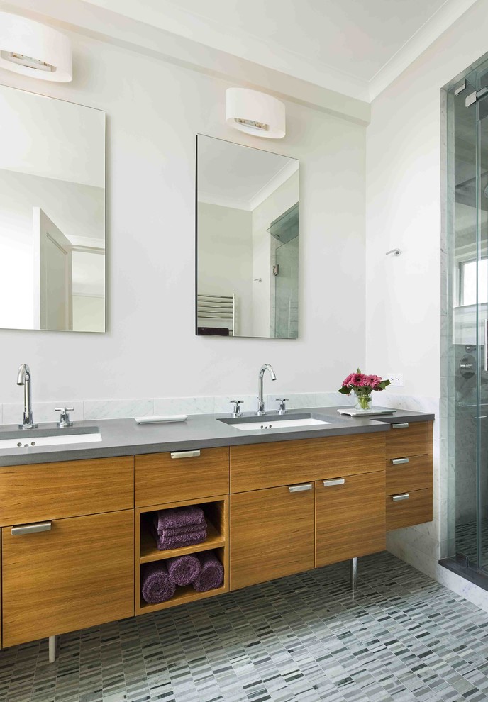 This is an example of a modern bathroom in New York with flat-panel cabinets and medium wood cabinets.