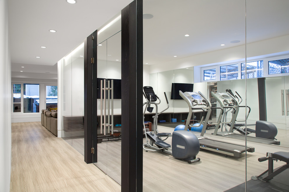 This is an example of a mid-sized modern multipurpose gym in Vancouver with white walls, vinyl floors and grey floor.