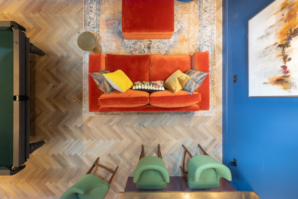 Diseño de sala de juegos en casa contemporánea grande sin chimenea con paredes azules, suelo de madera en tonos medios y suelo marrón