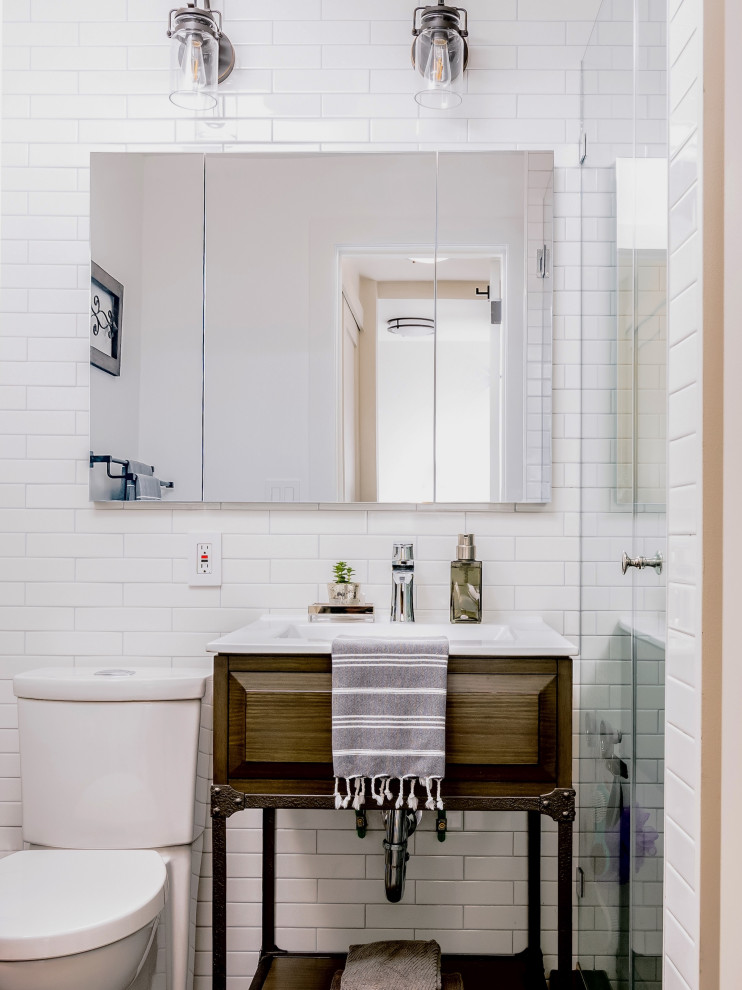 Bathroom - small industrial white tile and subway tile single-sink bathroom idea in New York with dark wood cabinets, a two-piece toilet, an integrated sink, a hinged shower door, white countertops and a freestanding vanity