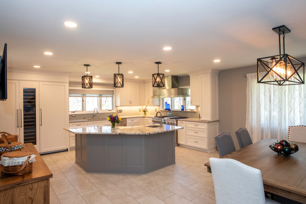 Large transitional l-shaped eat-in kitchen in Milwaukee with an undermount sink, shaker cabinets, white cabinets, granite benchtops, grey splashback, subway tile splashback, stainless steel appliances, porcelain floors, with island, grey floor and white benchtop.