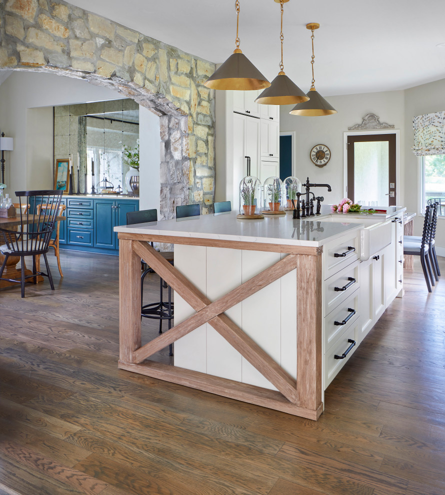 Example of a transitional light wood floor kitchen design in Denver with recessed-panel cabinets, white cabinets, an island and white countertops