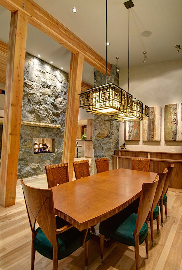 Large contemporary kitchen/dining combo in Denver with beige walls, light hardwood floors, a two-sided fireplace, a stone fireplace surround and brown floor.