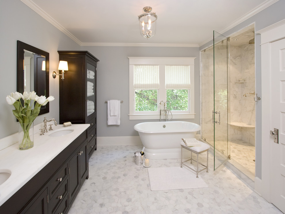Photo of a large traditional master bathroom in New York with a freestanding tub, grey floor, marble, white benchtops, recessed-panel cabinets, black cabinets, an alcove shower, blue walls, marble floors, an undermount sink and a hinged shower door.