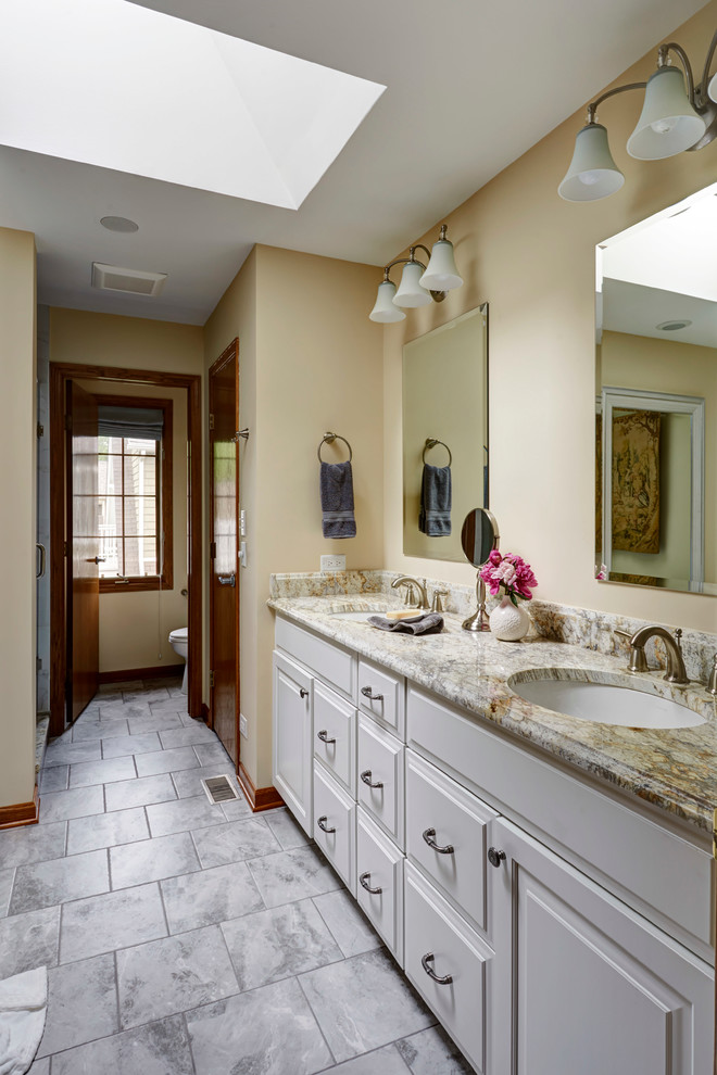 Design ideas for a mid-sized traditional master bathroom in San Francisco with raised-panel cabinets, white cabinets, a claw-foot tub, white tile, porcelain tile, yellow walls, porcelain floors, an undermount sink and granite benchtops.