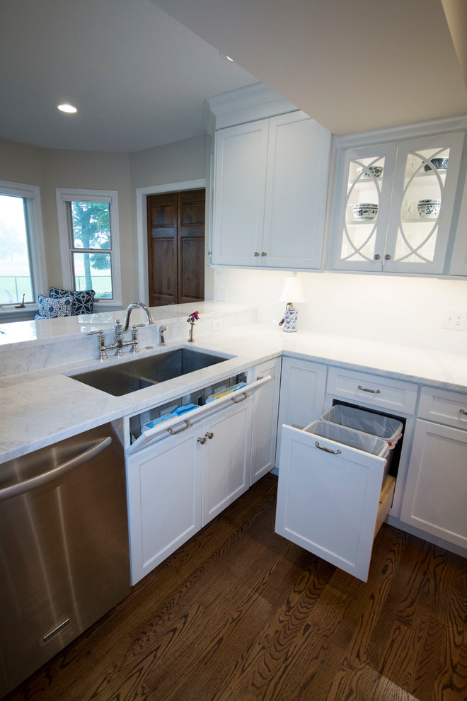Example of a huge transitional medium tone wood floor open concept kitchen design with an undermount sink, shaker cabinets, white cabinets, marble countertops, white backsplash, ceramic backsplash, stainless steel appliances and two islands