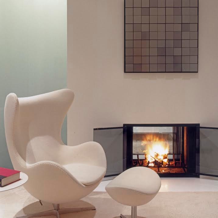 Inspiration for a mid-sized midcentury master bedroom in Portland with white walls, carpet, a two-sided fireplace, a plaster fireplace surround and white floor.