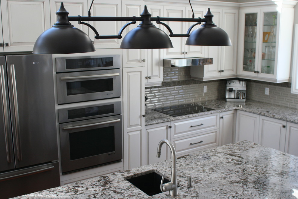Inspiration for a huge transitional l-shaped medium tone wood floor and brown floor open concept kitchen remodel in Montreal with an undermount sink, glass-front cabinets, white cabinets, granite countertops, gray backsplash, ceramic backsplash, stainless steel appliances, an island and multicolored countertops