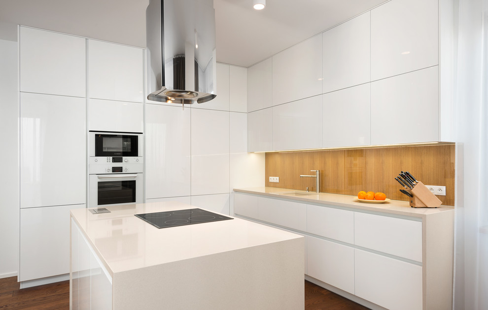 Design ideas for a mid-sized modern l-shaped eat-in kitchen in Other with an undermount sink, flat-panel cabinets, white cabinets, glass sheet splashback, white appliances, dark hardwood floors and with island.