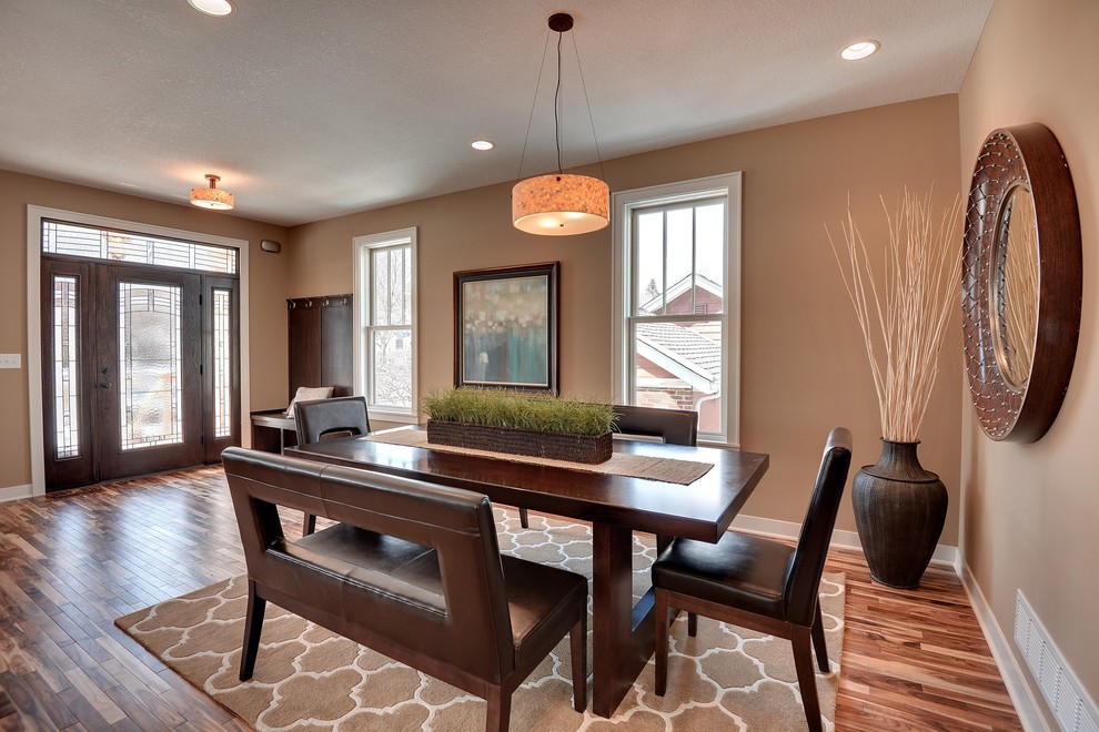 Photo of a transitional dining room in Minneapolis with brown walls and dark hardwood floors.
