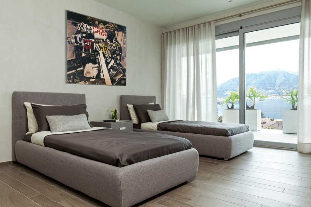 Mid-sized modern guest bedroom in Milan with beige walls and porcelain floors.