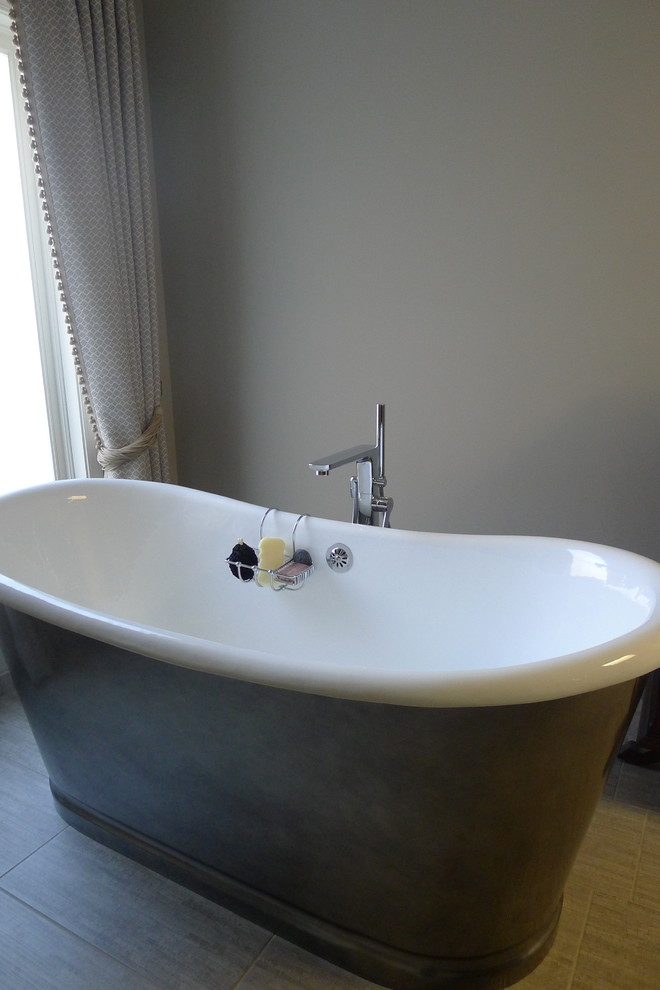 Large transitional master gray tile and porcelain tile porcelain tile freestanding bathtub photo in Indianapolis with a drop-in sink, furniture-like cabinets, dark wood cabinets, solid surface countertops, a one-piece toilet and gray walls