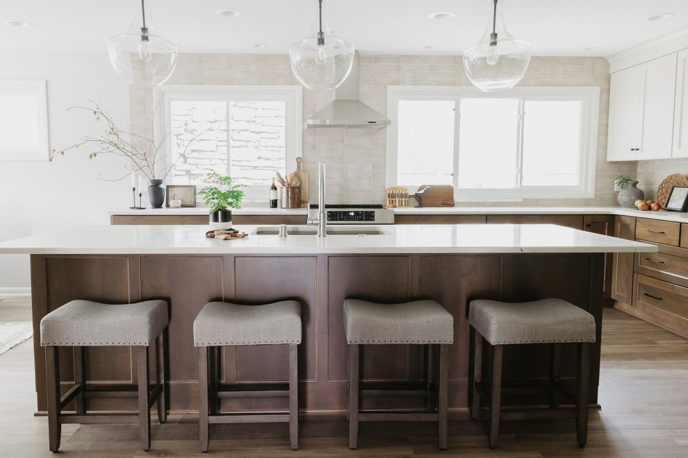 Eat-in kitchen - mid-sized transitional l-shaped vinyl floor and brown floor eat-in kitchen idea with an undermount sink, shaker cabinets, medium tone wood cabinets, quartz countertops, beige backsplash, porcelain backsplash, stainless steel appliances, an island and white countertops