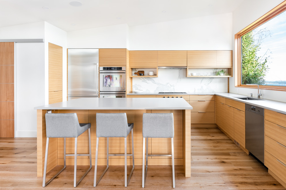 Design ideas for a transitional l-shaped eat-in kitchen in Vancouver with a double-bowl sink, flat-panel cabinets, medium wood cabinets, white splashback, stainless steel appliances, medium hardwood floors, with island, brown floor and grey benchtop.