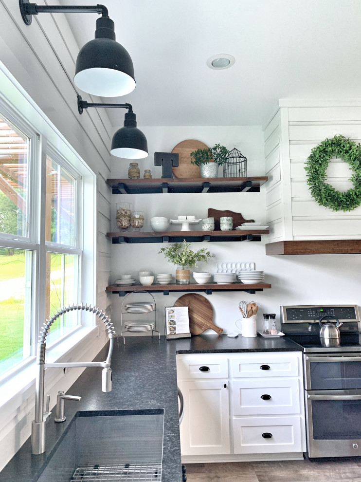 Inspiration for a large country u-shaped eat-in kitchen with an undermount sink, shaker cabinets, white cabinets, granite benchtops, yellow splashback, shiplap splashback, stainless steel appliances, vinyl floors, with island, grey floor and black benchtop.