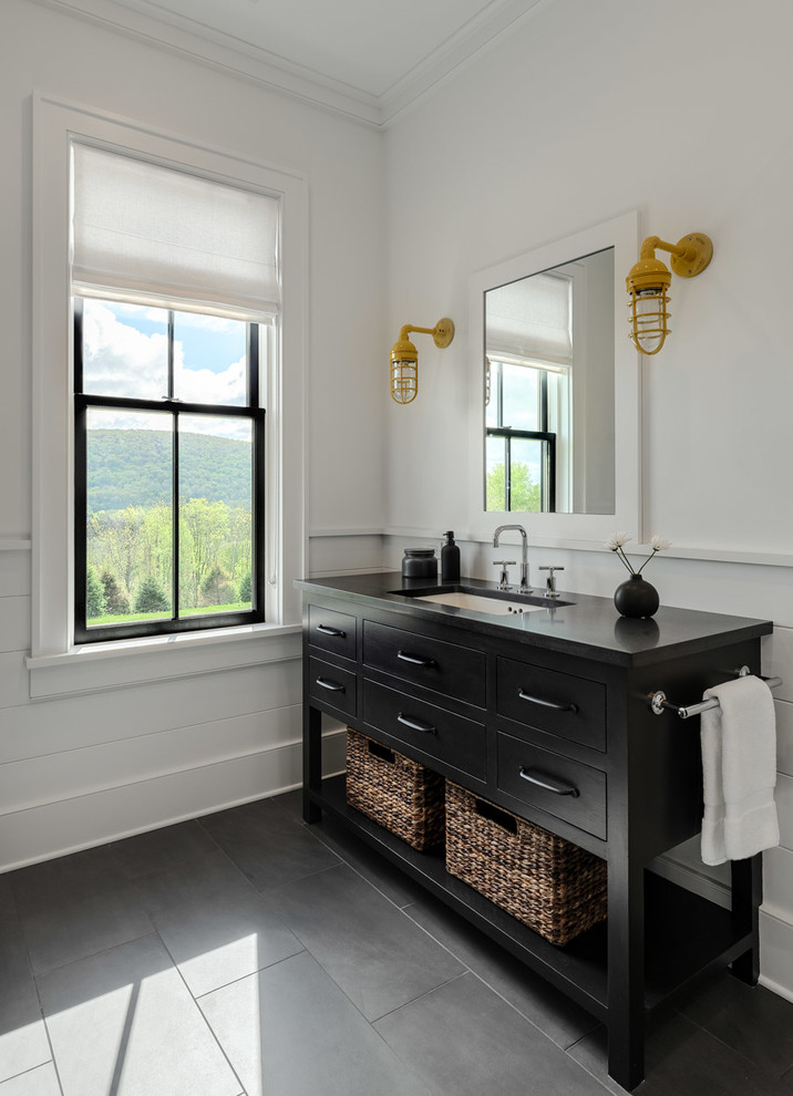 Photo of a large country kids bathroom in New York with flat-panel cabinets, black cabinets, white walls, slate floors, an undermount sink, grey floor and black benchtops.