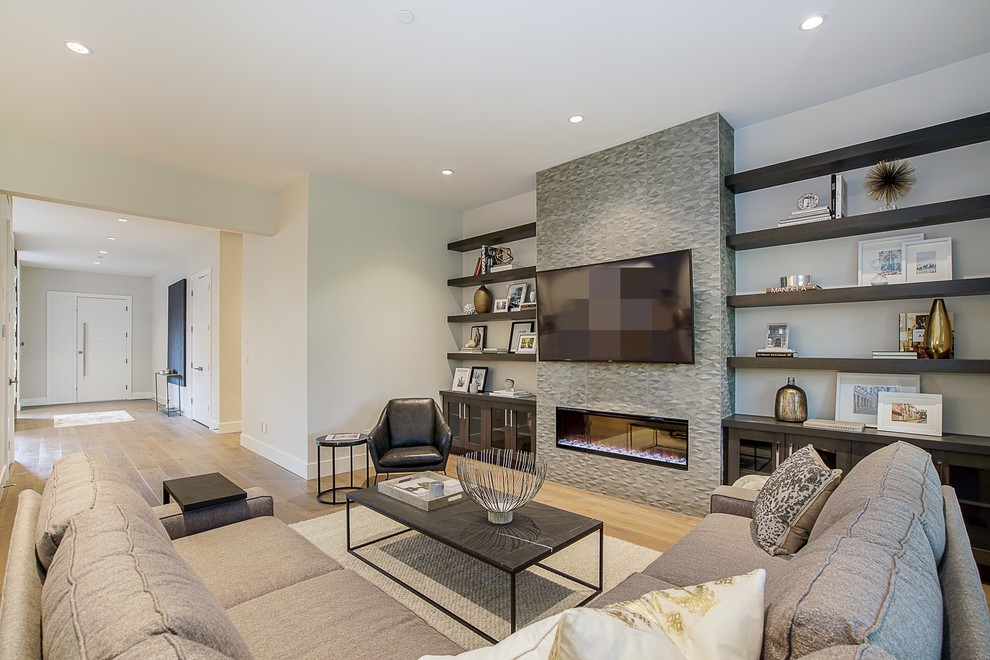 Inspiration for a mid-sized contemporary open concept family room in Vancouver with white walls, medium hardwood floors, a ribbon fireplace, a tile fireplace surround, a wall-mounted tv and brown floor.