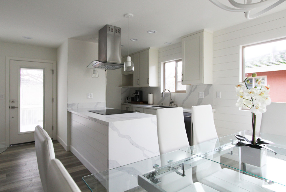 Inspiration for a small galley vinyl floor and brown floor open concept kitchen remodel with an undermount sink, shaker cabinets, white cabinets, quartz countertops, white backsplash, quartz backsplash, stainless steel appliances, a peninsula and white countertops