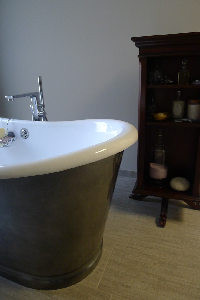 Inspiration for a large transitional master gray tile and porcelain tile porcelain tile freestanding bathtub remodel in Indianapolis with a drop-in sink, furniture-like cabinets, dark wood cabinets, solid surface countertops, a one-piece toilet and gray walls